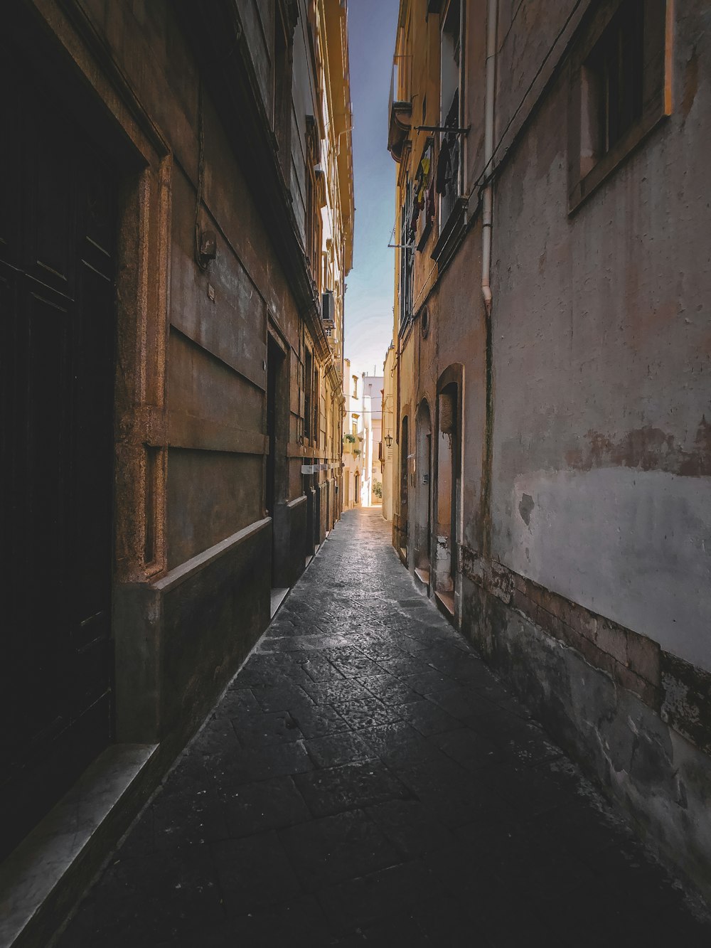 empty hallway between concrete buildings during daytime