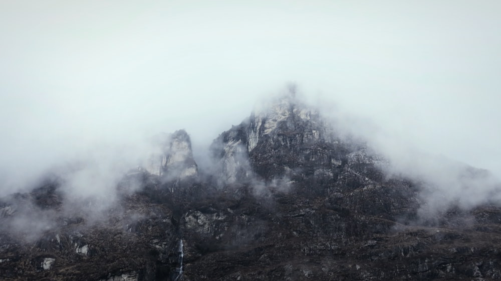 gray and black mountain covered with fog