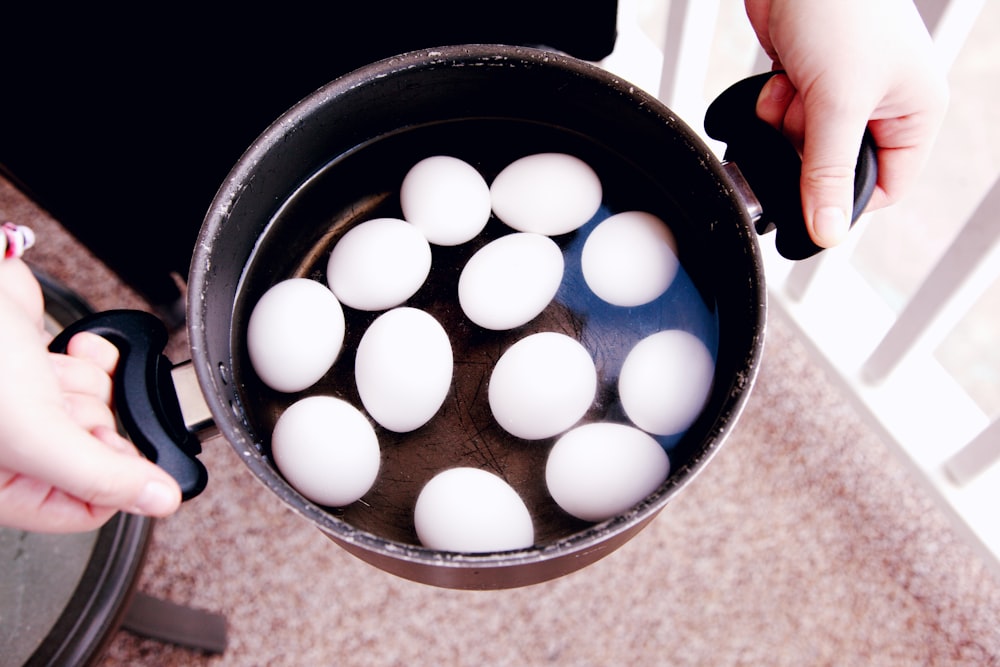 weiße Eier in schwarzem runden Behälter