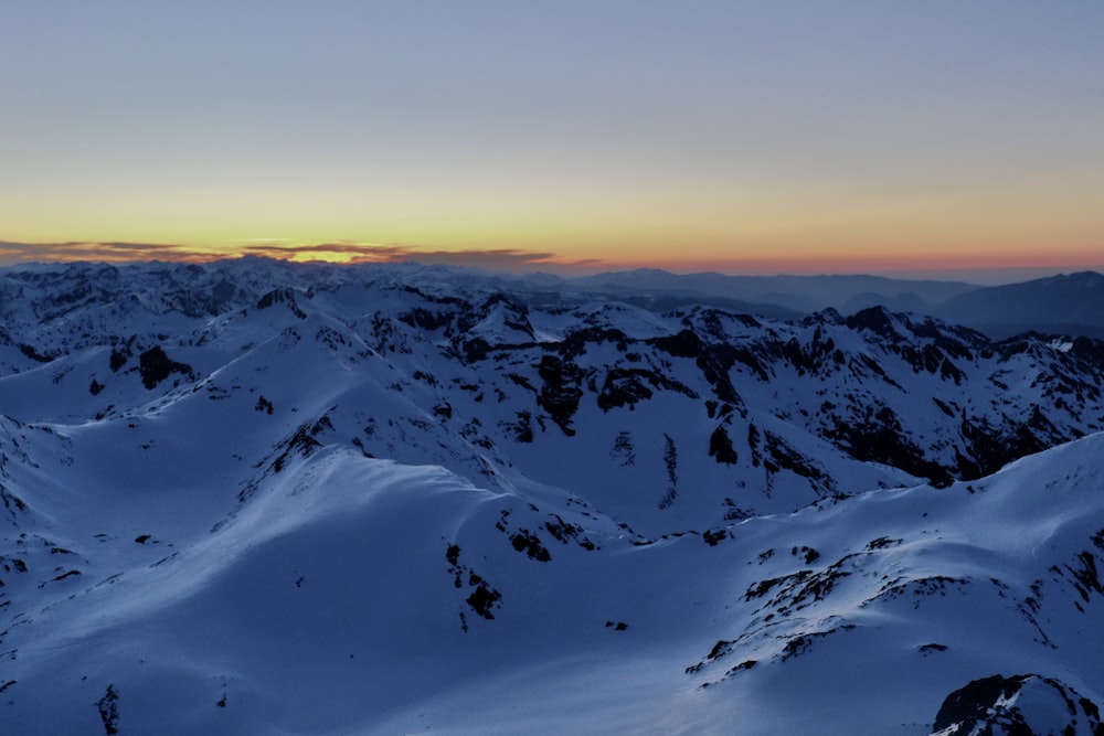 snow covered mountains during sunset