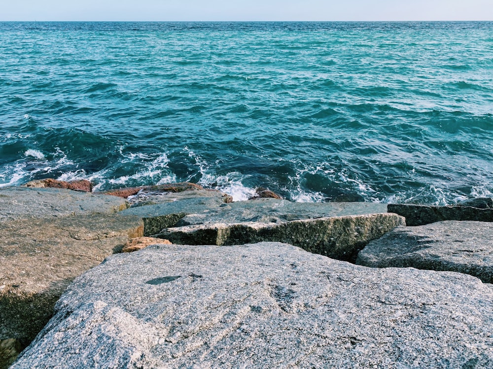 brown rocky shore near body of water during daytime