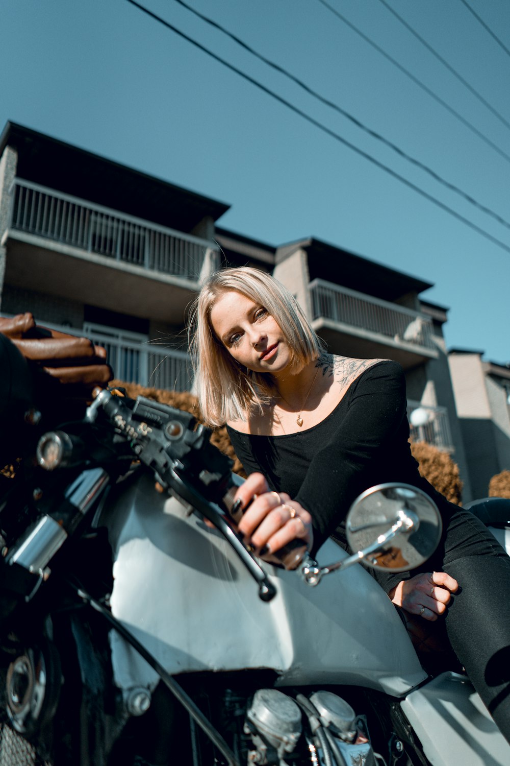 femme en chemise noire conduisant une moto pendant la journée