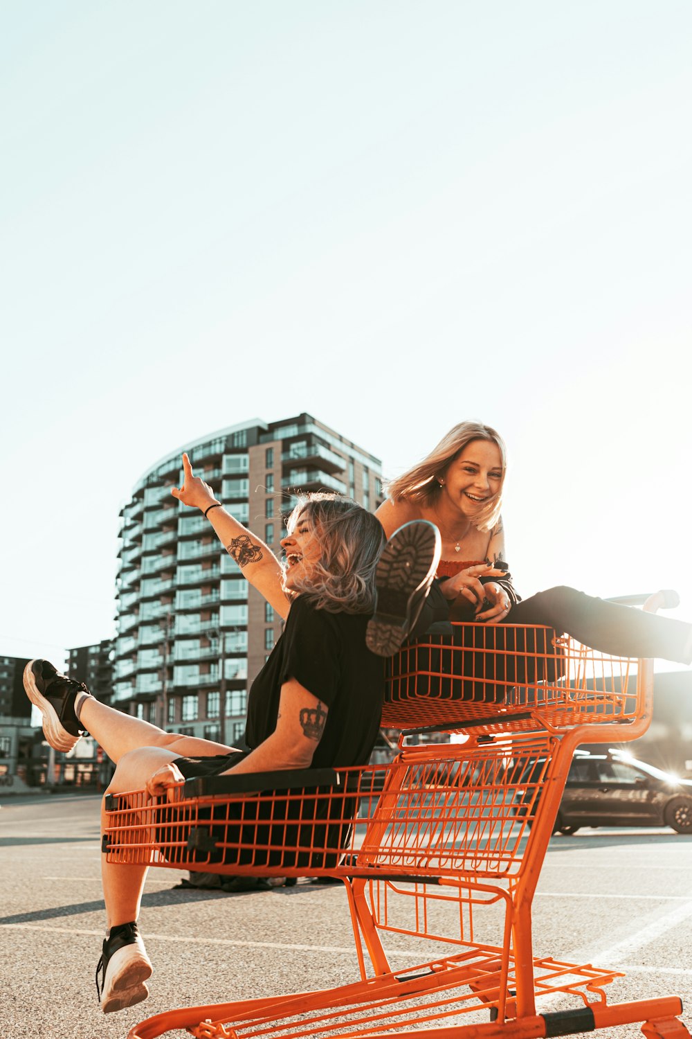 Mujer en vestido negro sosteniendo el carrito de la compra