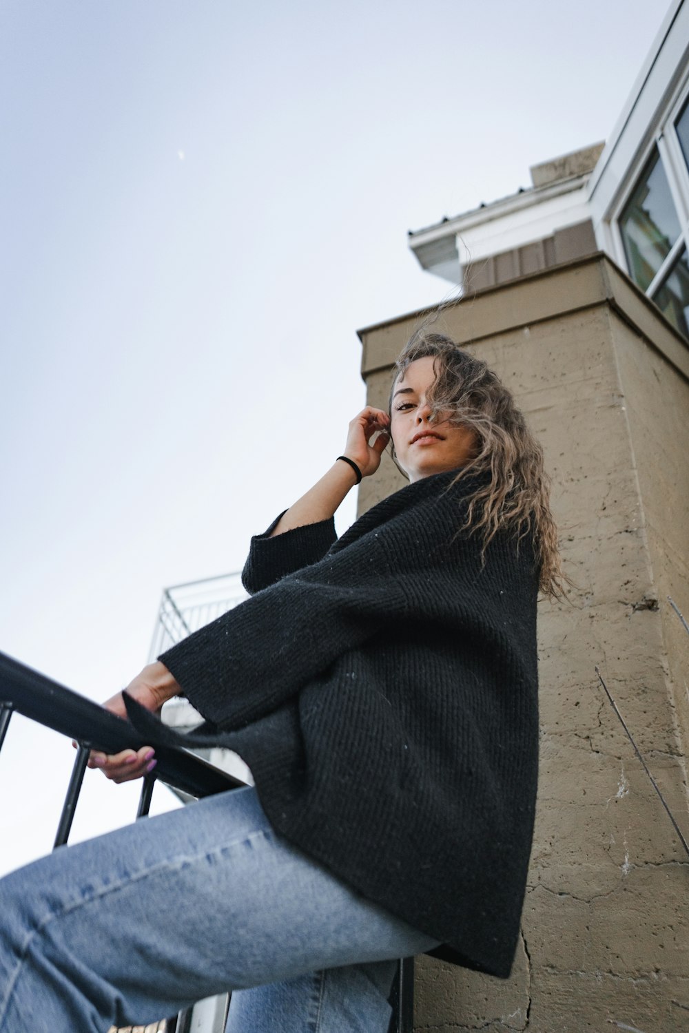 woman in black sweater standing on stairs