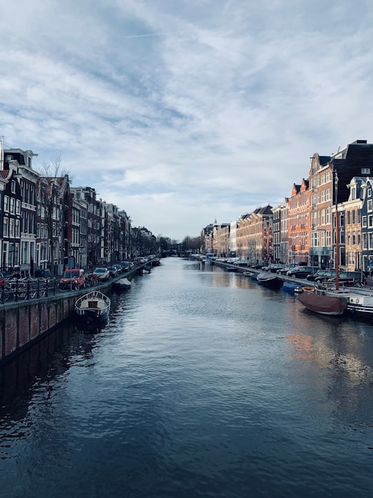 boat on river between buildings during daytime in Rijksmuseum Netherlands