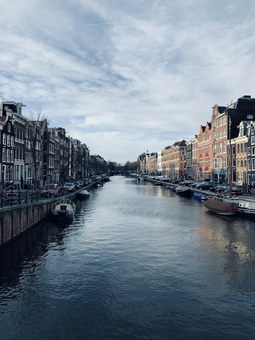 boat on river between buildings during daytime