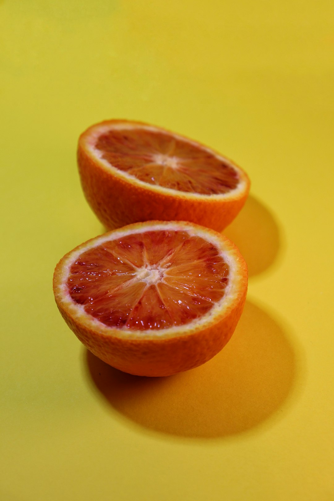 sliced orange fruit on yellow surface