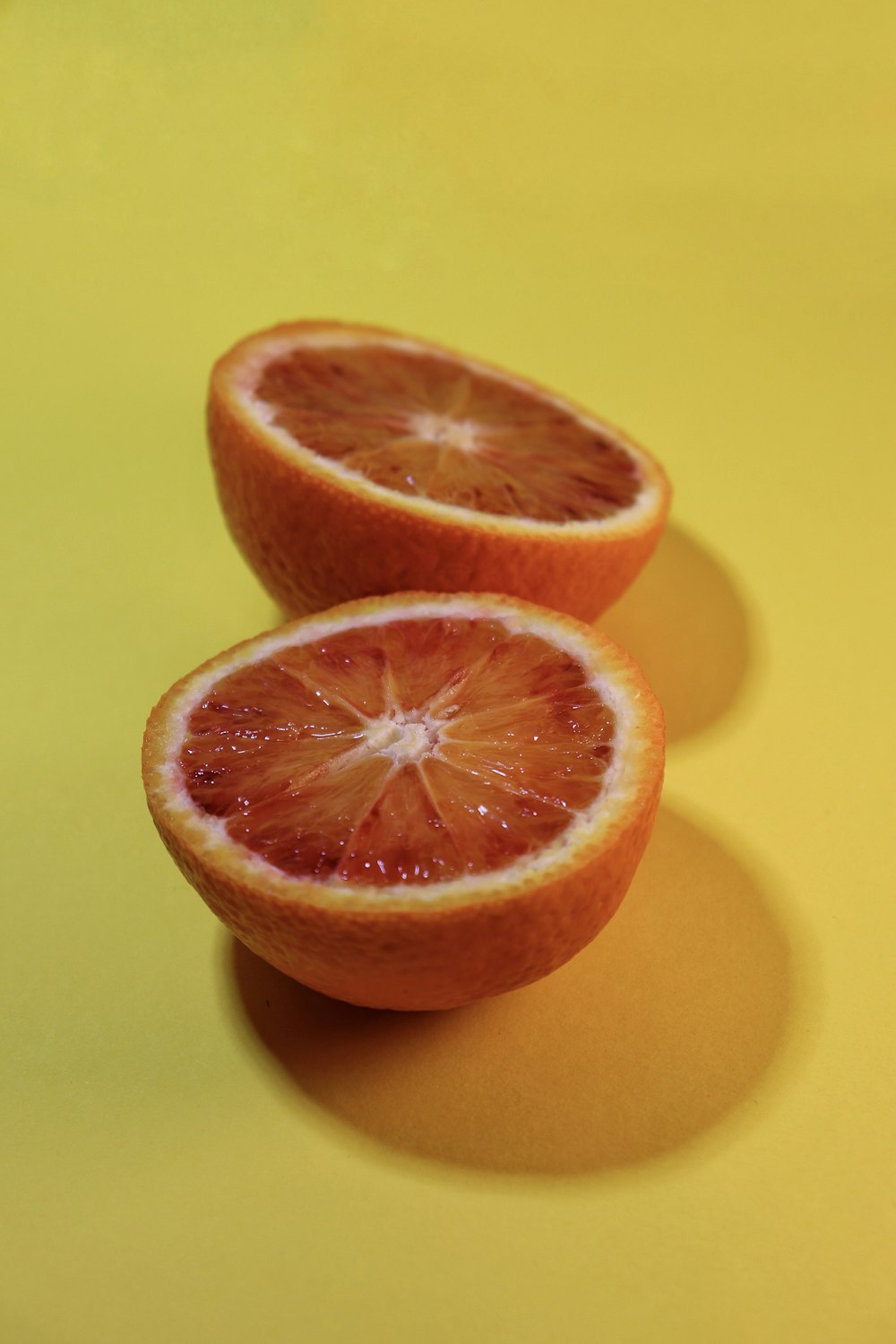 in Scheiben geschnittene Orangenfrüchte auf gelber Oberfläche