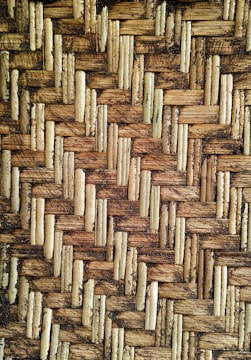Detailed texture of a woven pattern made from interlaced natural fibers, showcasing an intricate and rustic design.