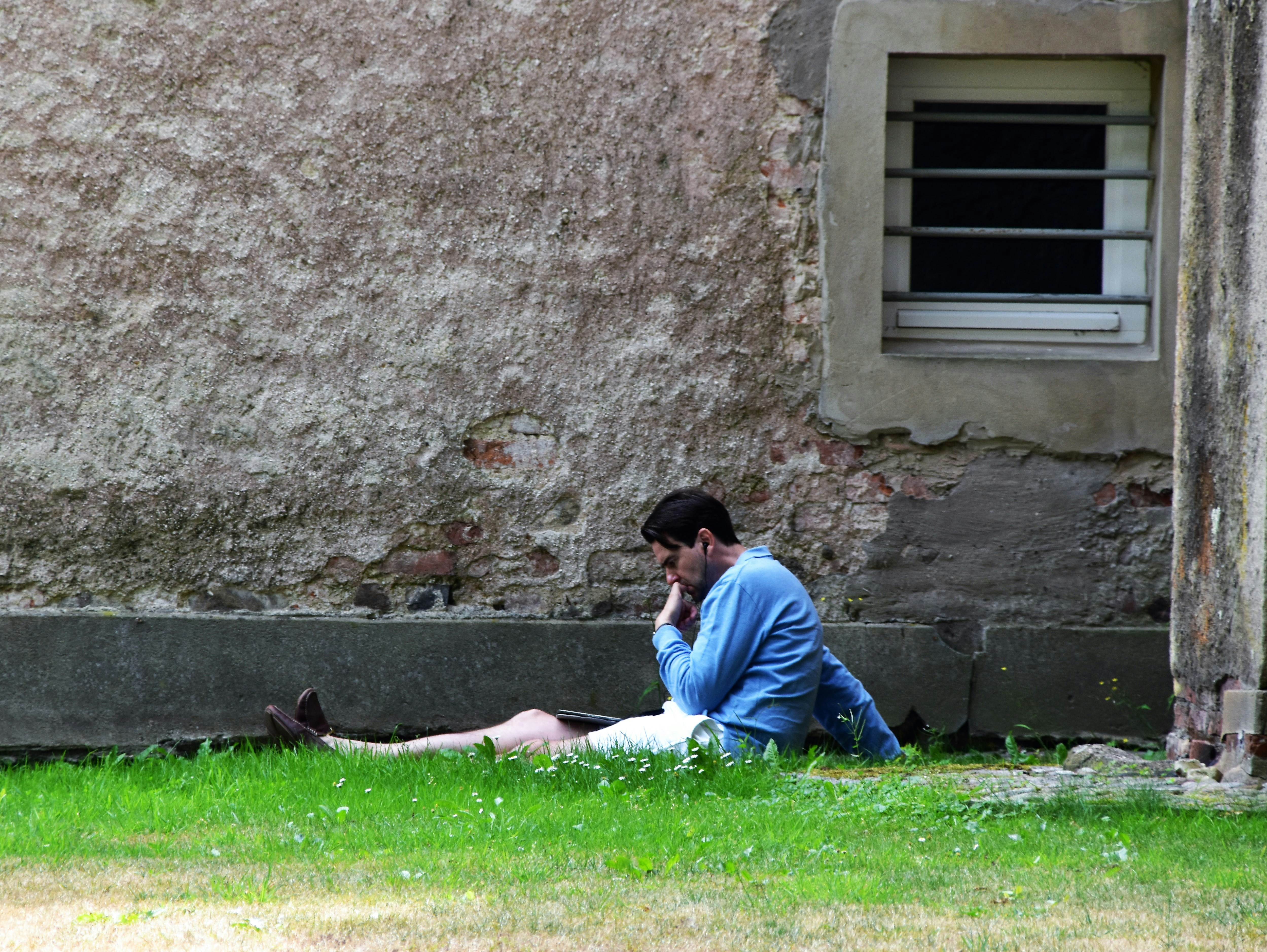 resident reading in apartment courtyard - green space apartments