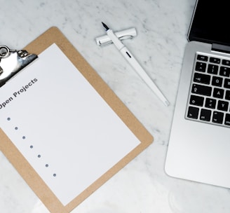 white printer paper beside silver laptop computer