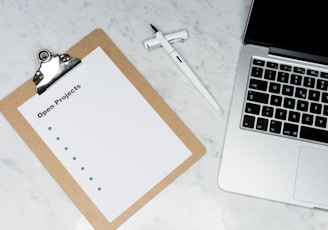 white printer paper beside silver laptop computer