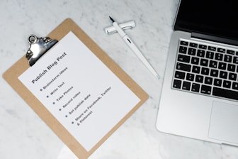 white printer paper beside silver macbook