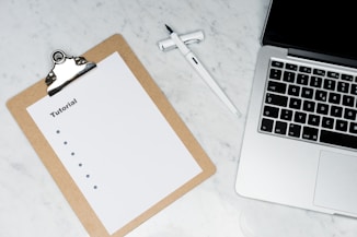 white paper on brown folder beside silver key