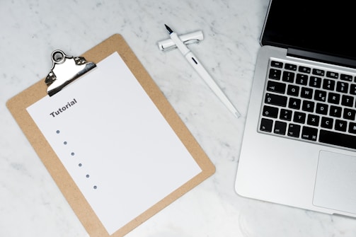 white paper on brown folder beside silver key