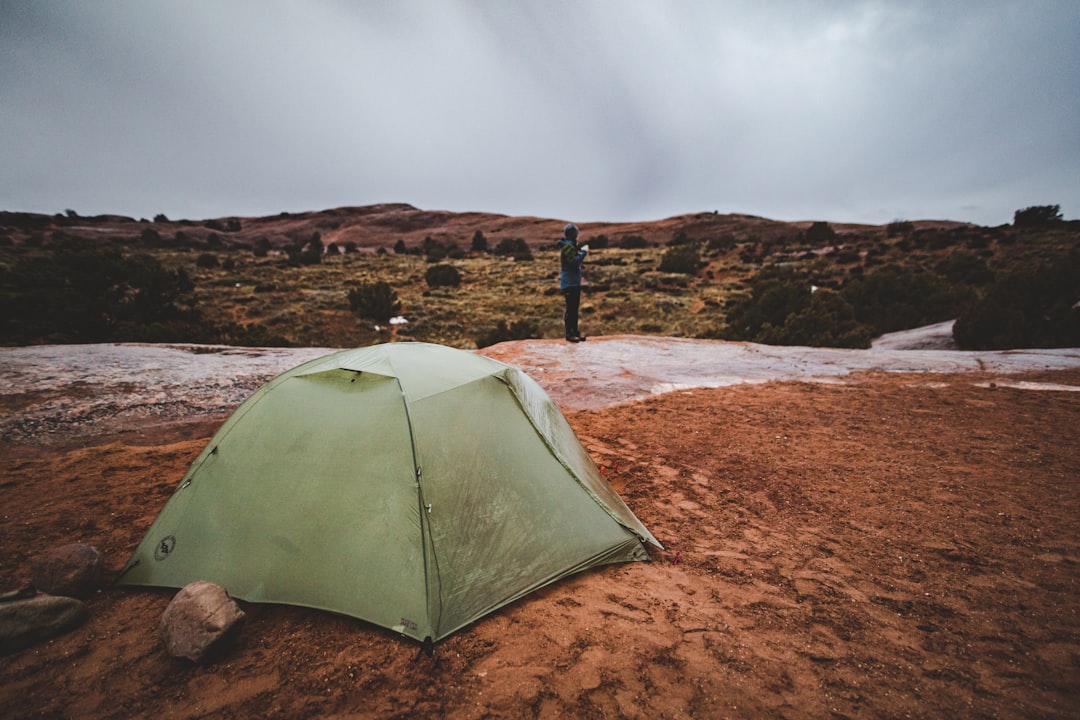 green dome tent on brown sand under gray sky