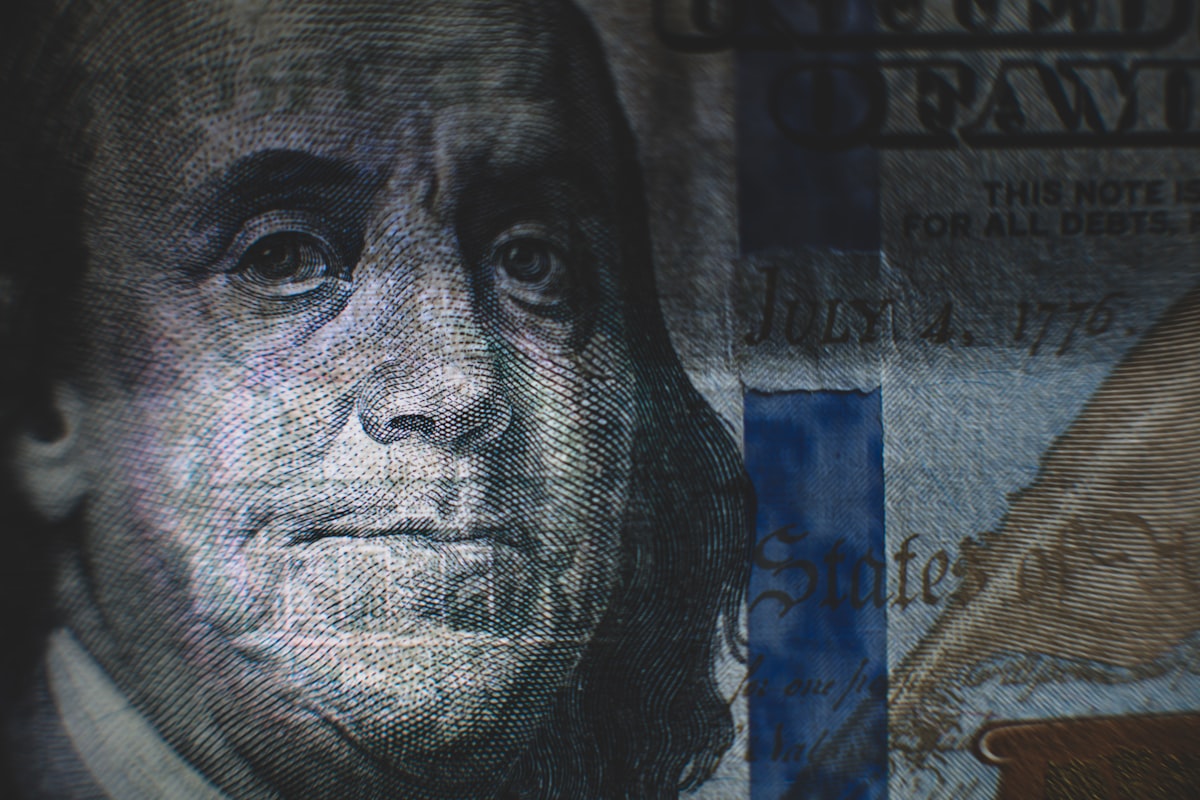 Close-up of a US one hundred dollar bill against a gray background