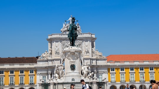 people sitting on horse statue during daytime in Praça do Comércio Portugal