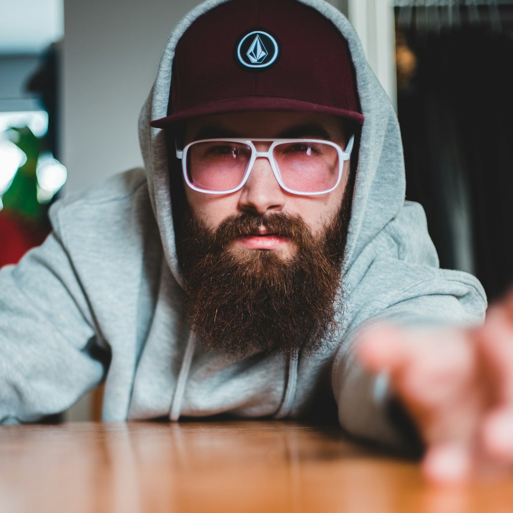 man in gray hoodie wearing black and red cap