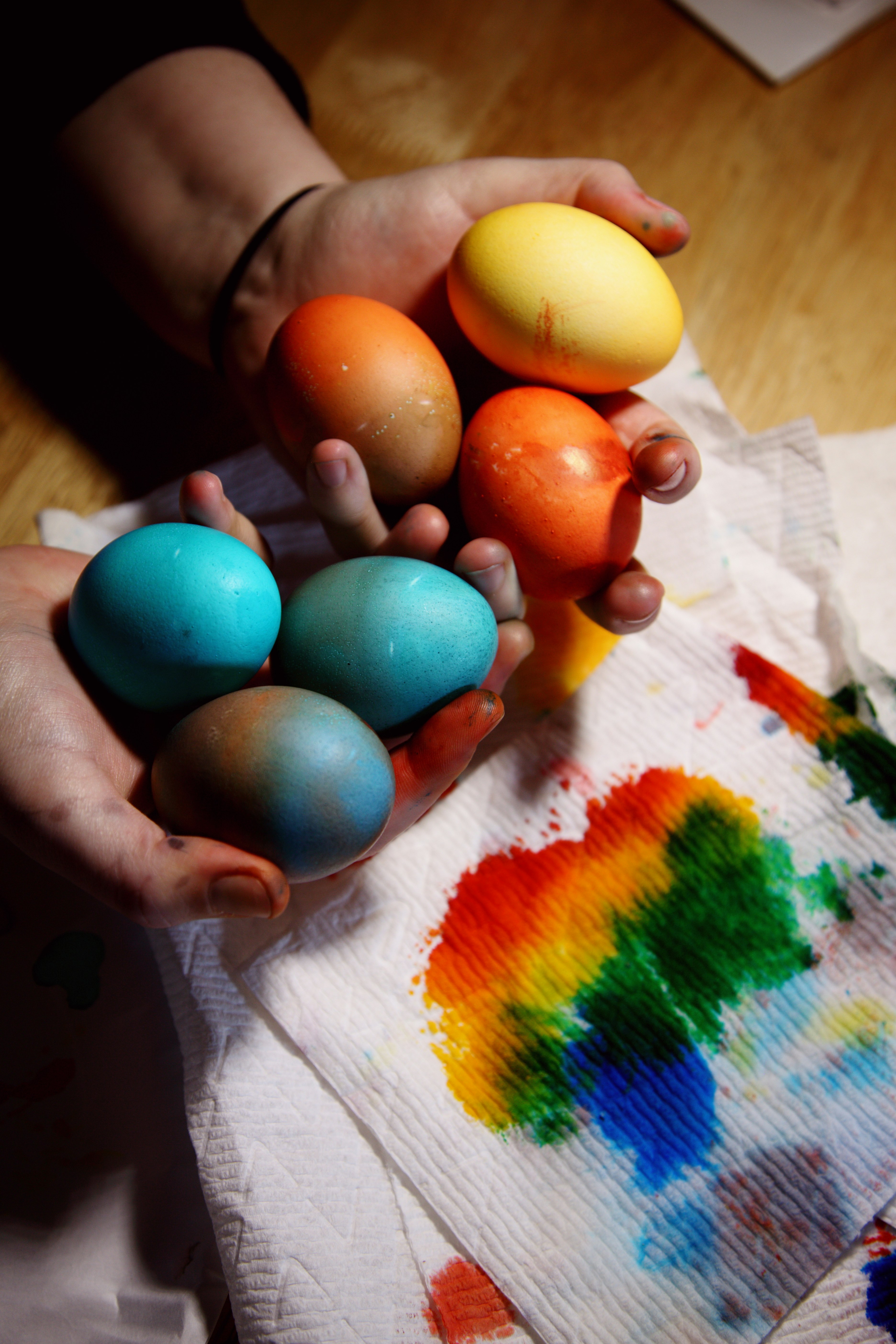 person holding blue and yellow egg