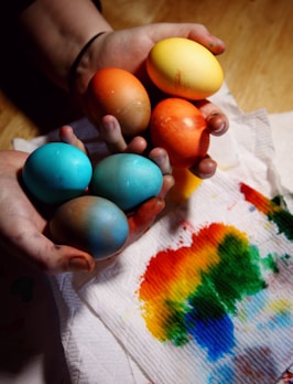 person holding blue and yellow egg