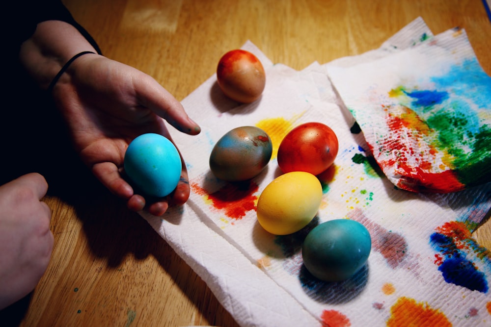 person holding red yellow and blue egg