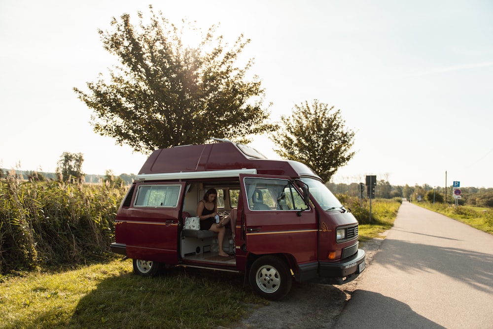 red and brown van on green grass field during daytime