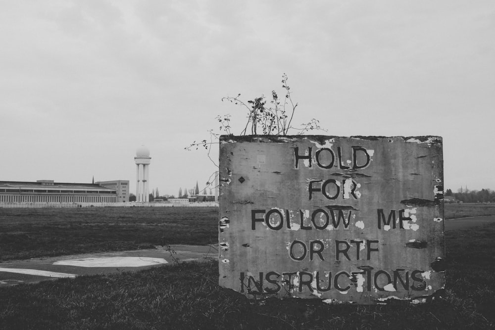 a black and white photo of a sign that says hold for follow me or rt