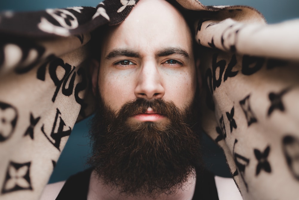 man in black tank top lying on white and black textile