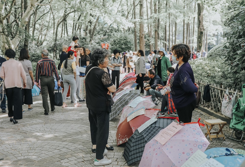 a group of people standing around with umbrellas