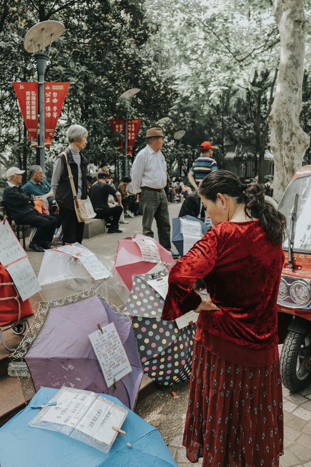 woman in red long sleeve shirt holding white and red umbrella