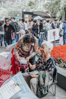 A group of women gathered outdoors, sharing stories and laughter with their journals in hand.