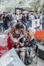 A group of mothers sharing stories and support during a community gathering outdoors.