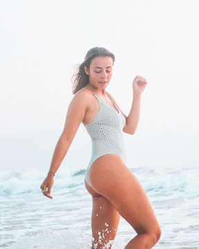 woman in white and black stripe swimsuit standing on water during daytime