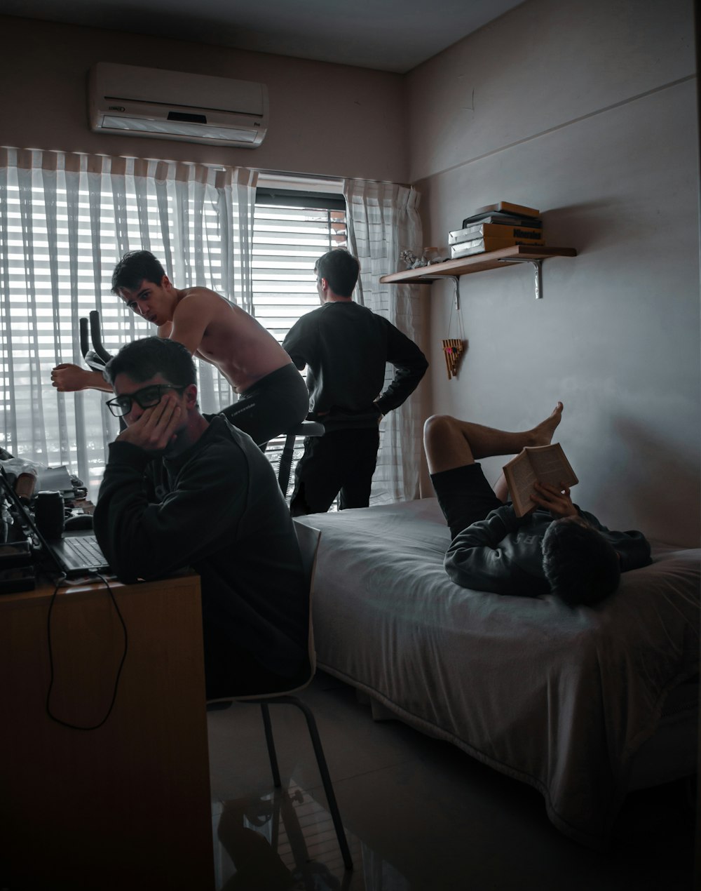 homem de camiseta preta e shorts pretos sentados na cama