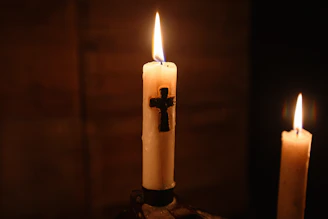 Soft candlelight flickering beside a cross, creating a warm and inviting atmosphere.