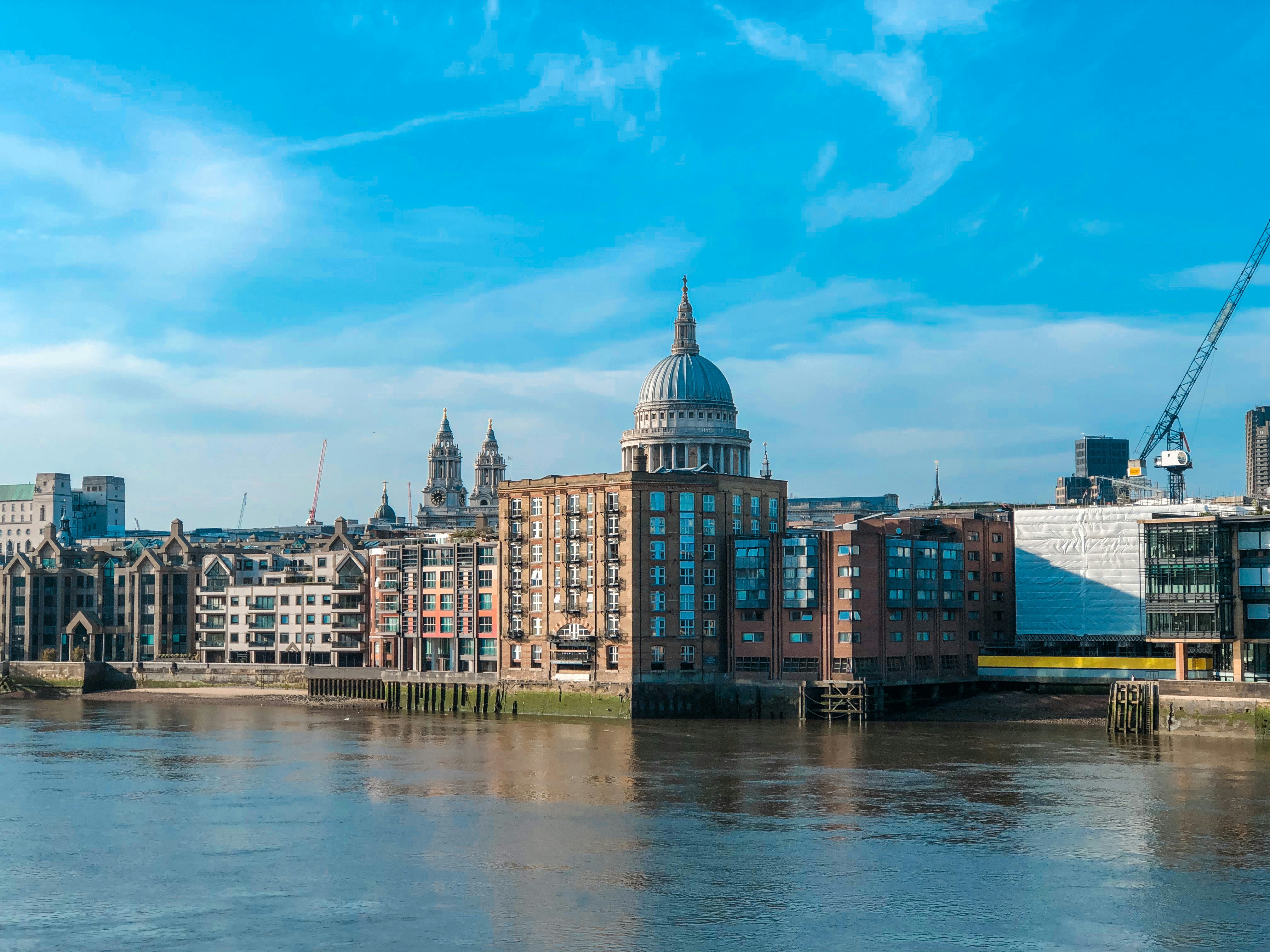 brown and white concrete building near body of water under blue sky during daytime