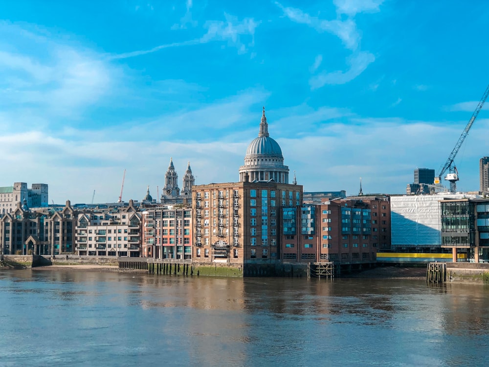 brown and white concrete building near body of water under blue sky during daytime