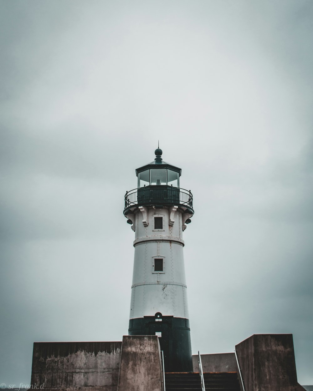 white and black lighthouse under cloudy sky