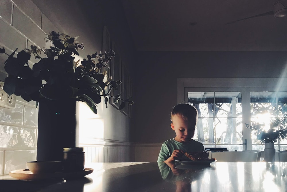 boy in green and white striped long sleeve shirt sitting on chair