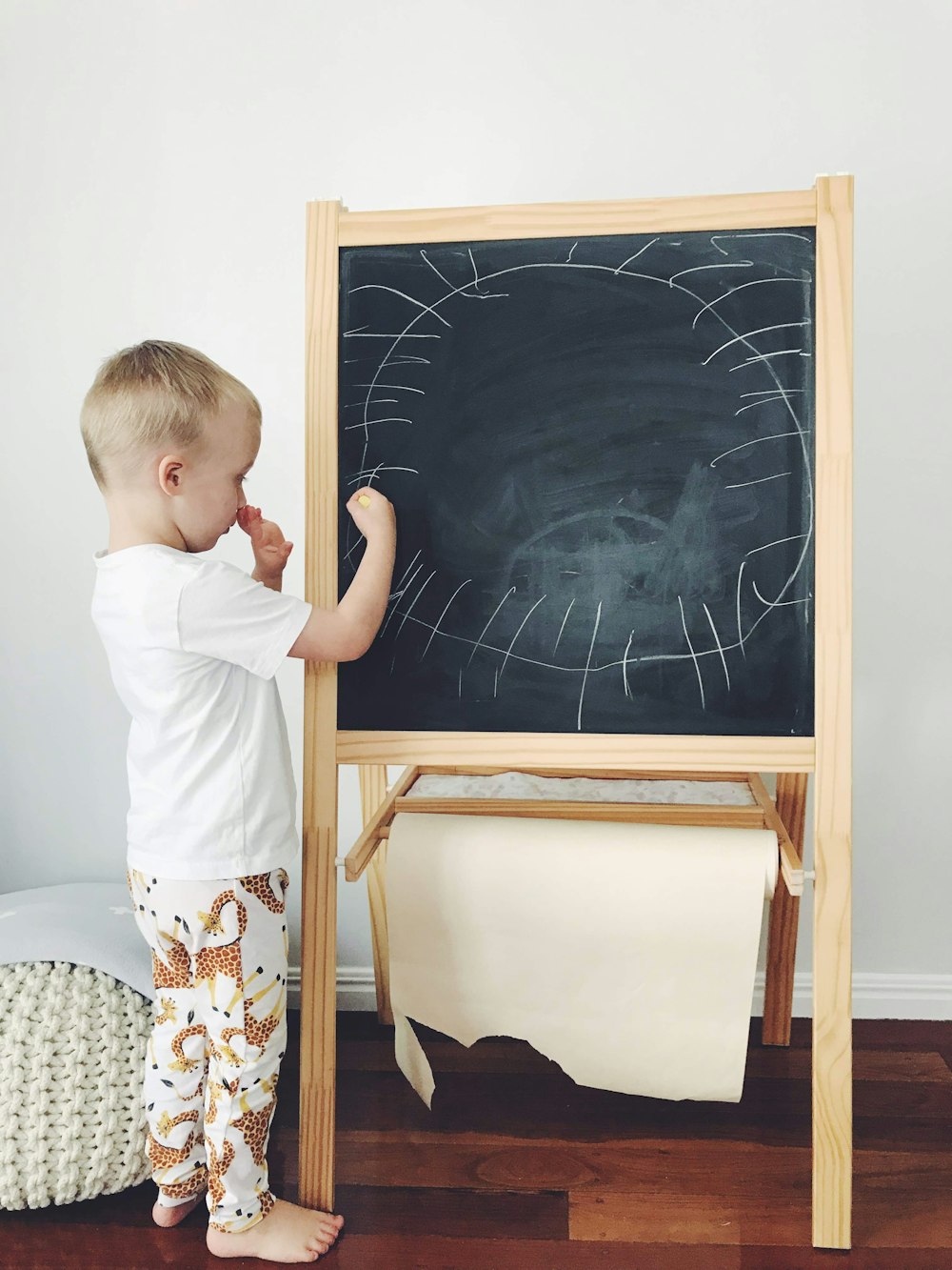 boy in white shirt standing beside black and brown wooden framed black and white map