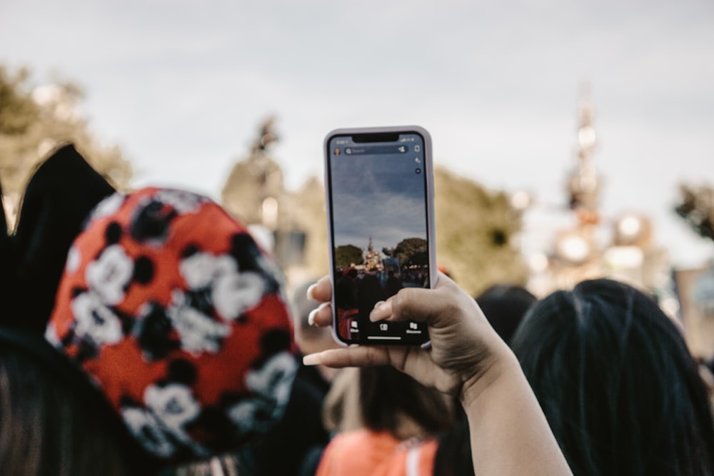 Person mit schwarzem iPhone 5 fotografiert tagsüber weiße Wolken