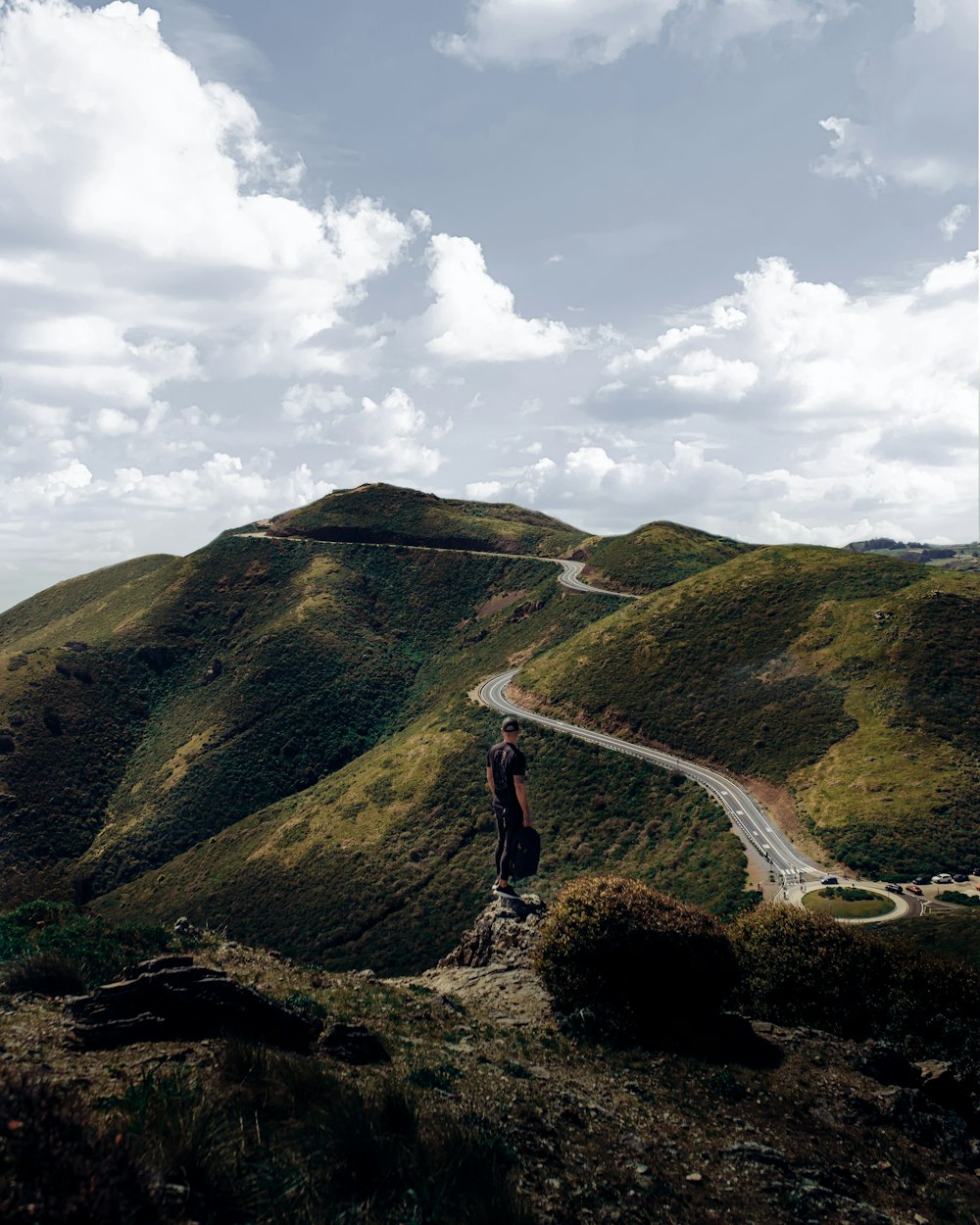 woman in black tank top and red pants standing on brown rock mountain during daytime