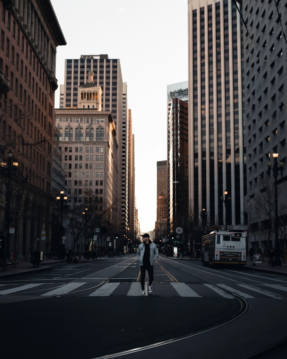 man in black jacket and black pants walking on pedestrian lane during daytime