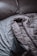 A pair of crumpled, gray bed sheets and pillows create a relaxed, unmade appearance. The rumpled bedding suggests hint of recent use, and the soft texture is visible in its folds.