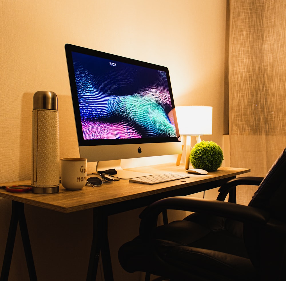 silver imac on brown wooden table