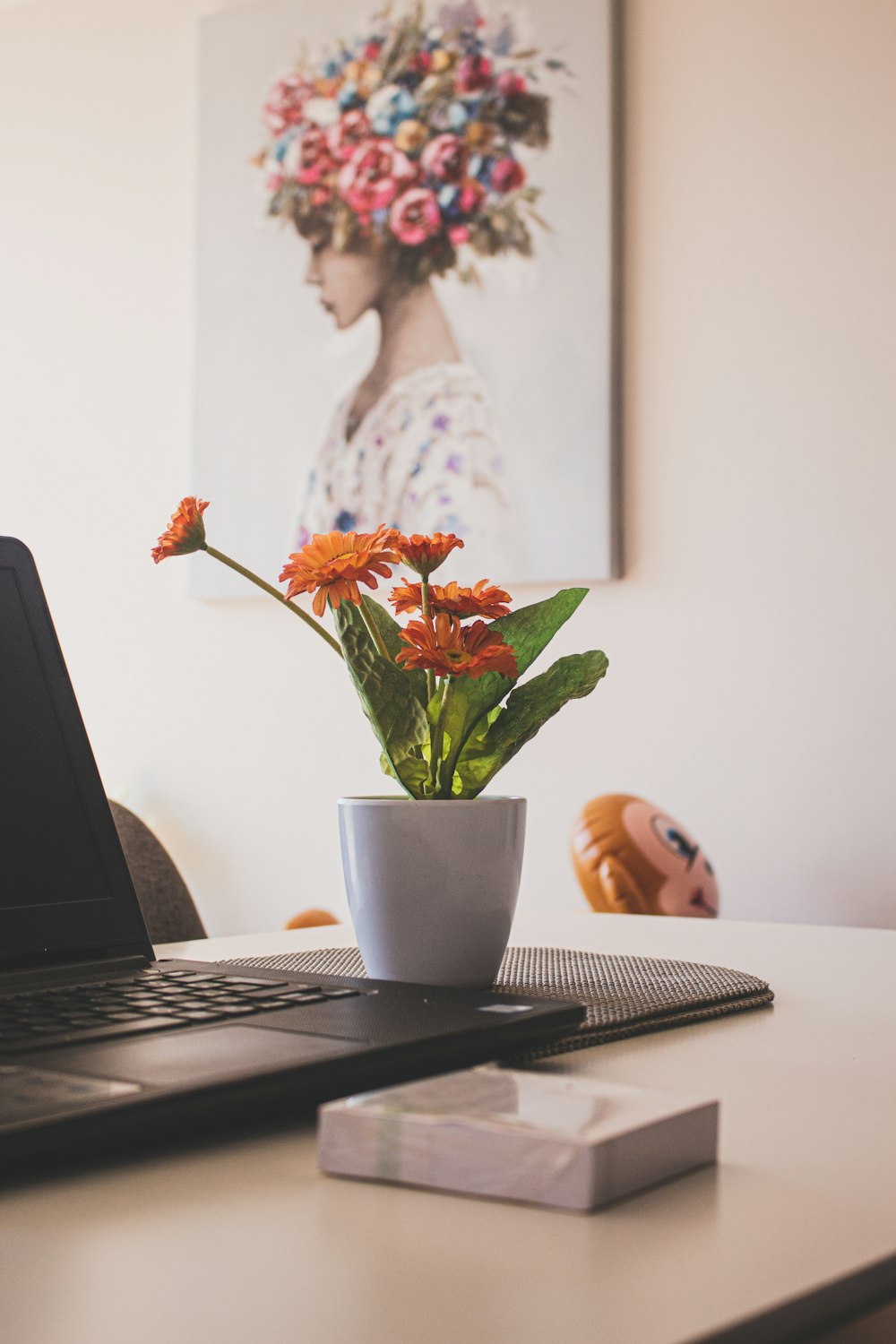 macbook pro beside white ceramic mug on table