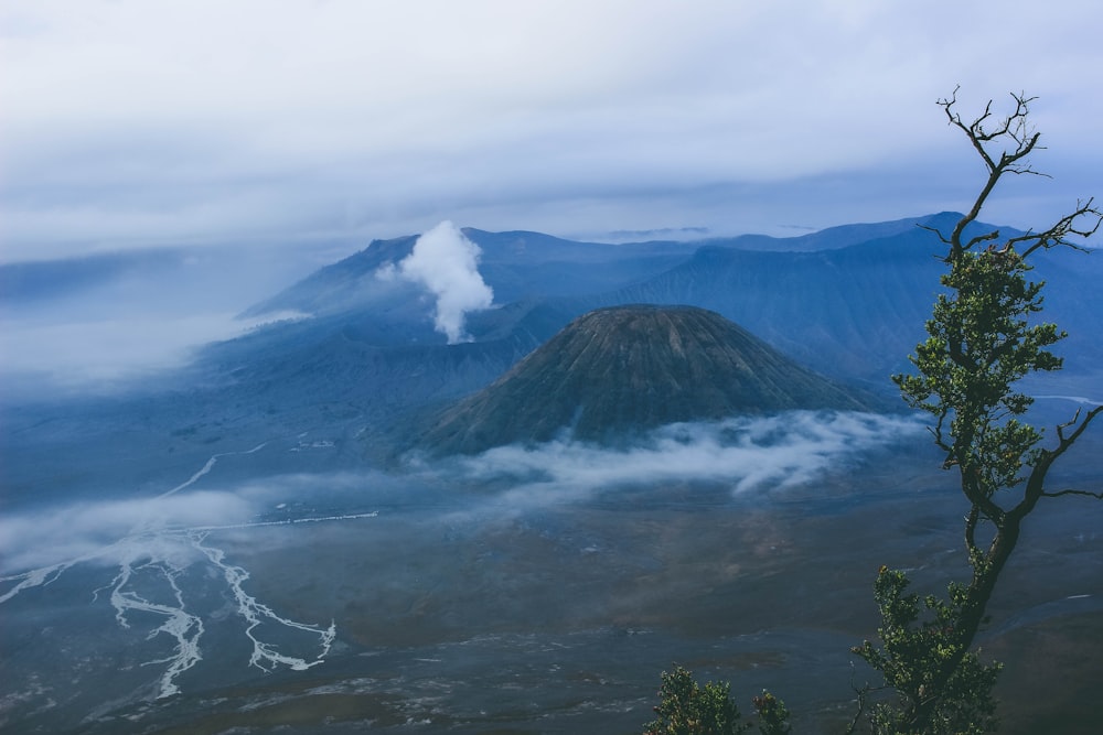 brown and green mountain under white clouds during daytime