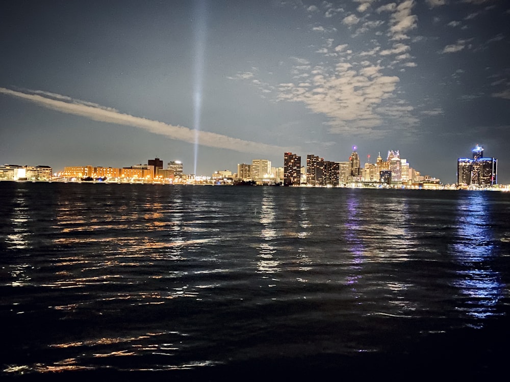 city skyline across body of water during night time