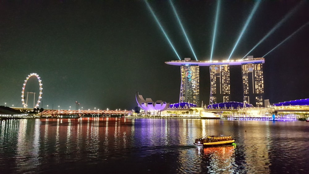 green and white concrete building near body of water during night time